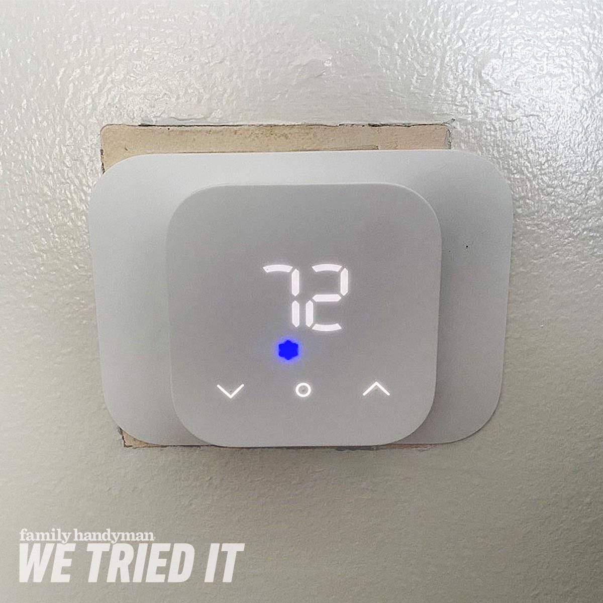 A digital thermostat displays the temperature as 72°F. It is mounted on a white wall with a blue indicator light visible.