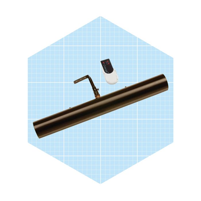 A black cylindrical light fixture rests mounted on a bracket, with a remote control placed nearby, set against a light blue grid background.
