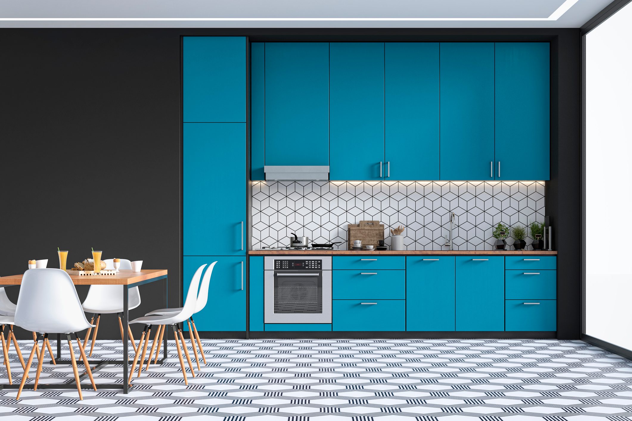 A modern kitchen features vibrant blue cabinets, a stove, and a patterned floor, while a dining table is set with drinks and snacks nearby.