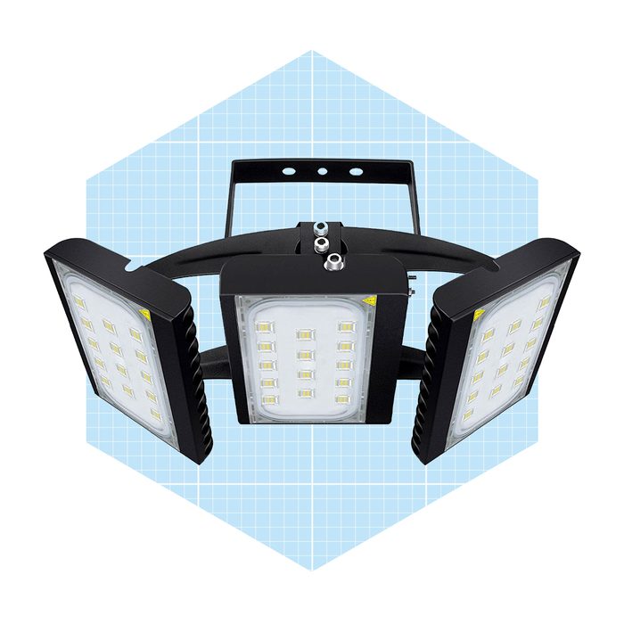 Three LED floodlights are mounted on a black bracket, designed to provide high-intensity illumination against a light blue grid background.