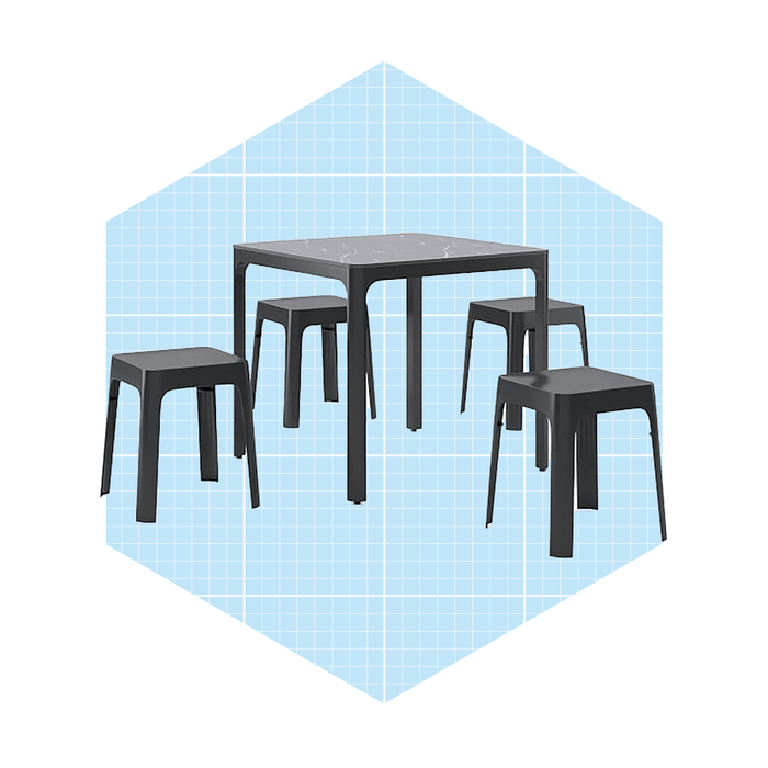 A rectangular table with a marble top and four matching stools stands on a light blue grid background, suggesting a modern dining or work space.