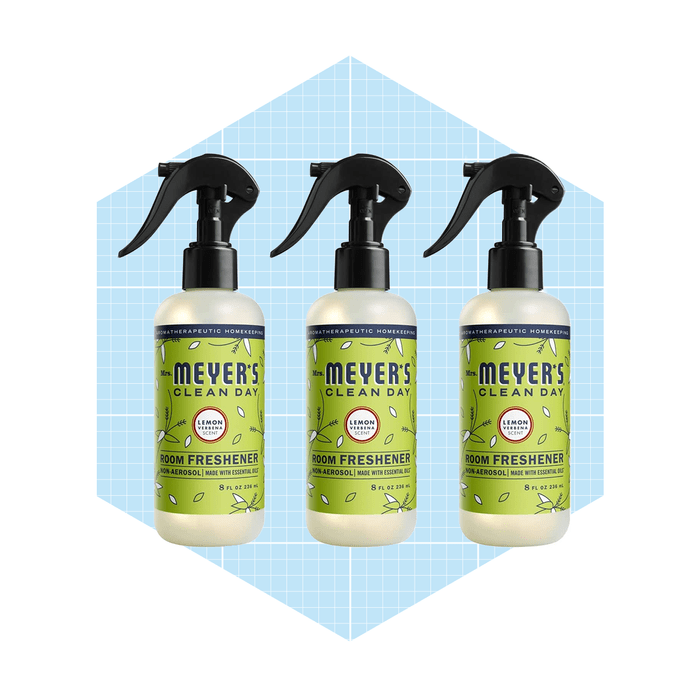 Three spray bottles of lemon-scented room freshener are positioned against a light blue grid background, emphasizing their design and fragrance focus.