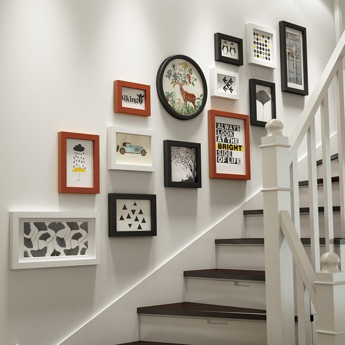 Framed artworks are arranged on a white wall beside a staircase, featuring various designs and colors, adding visual interest to the modern interior space.