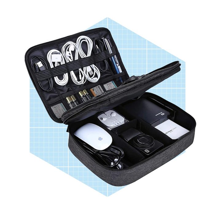 A black zippered case holds organized cables, pens, and devices, showcasing neat compartments against a light blue grid background.