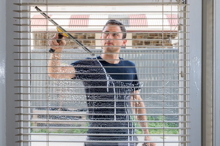 Inside view of a man washing a window