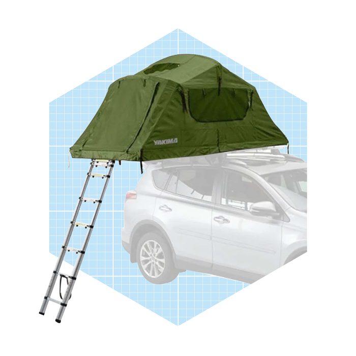 A green rooftop tent is positioned on top of an SUV, with an attached aluminum ladder for access, against a grid-pattern backdrop.
