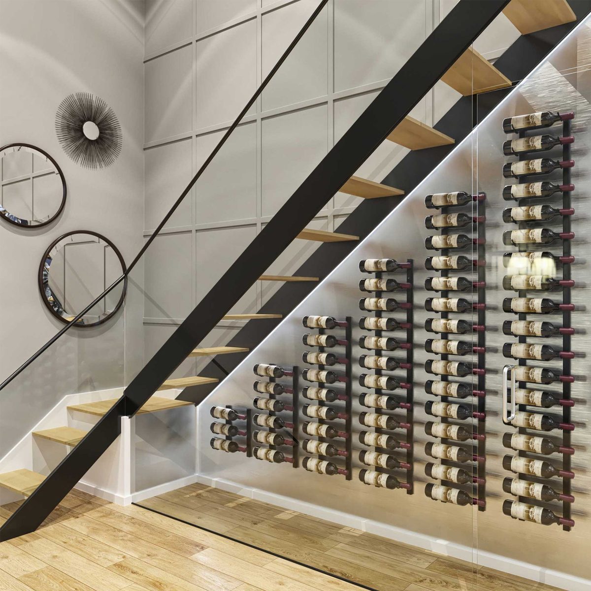 A wine rack holds numerous bottles against a wall beneath a staircase, with modern mirrors and a sleek design enhancing the contemporary interior space.
