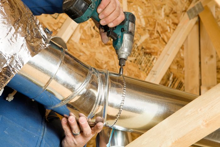 Worker Installing an Attic Vent Duct