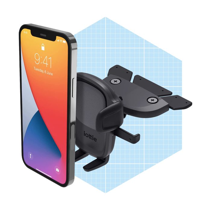 A smartphone is positioned next to a phone holder. The holder's arms extend outward, designed to secure the phone. The background features a light grid pattern.