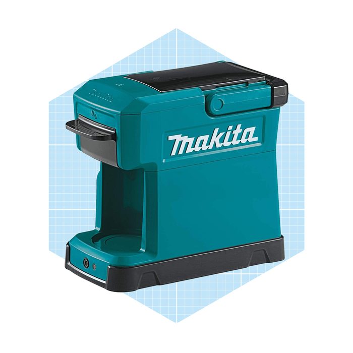 A turquoise Makita machine sits on a blue grid background, designed for tool organization with compartments and buttons for operation.