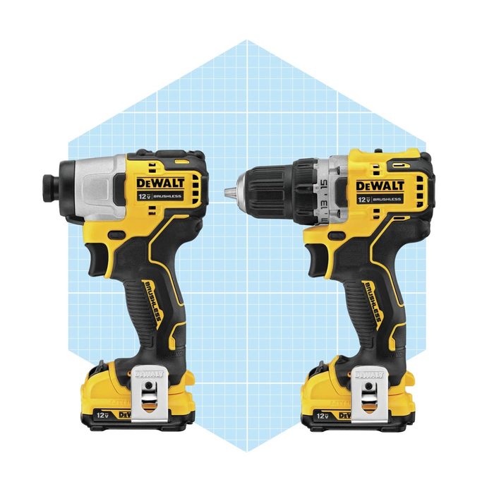 Two yellow-and-black DEWALT power tools, a drill and an impact driver, are positioned side-by-side against a light blue grid background.