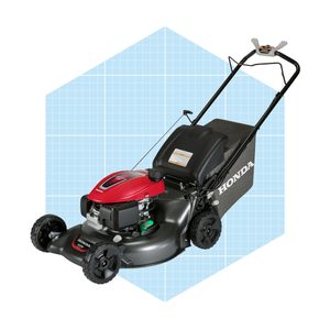 A lawn mower with a red engine and black body sits against a blue grid background, ready for use in cutting grass.