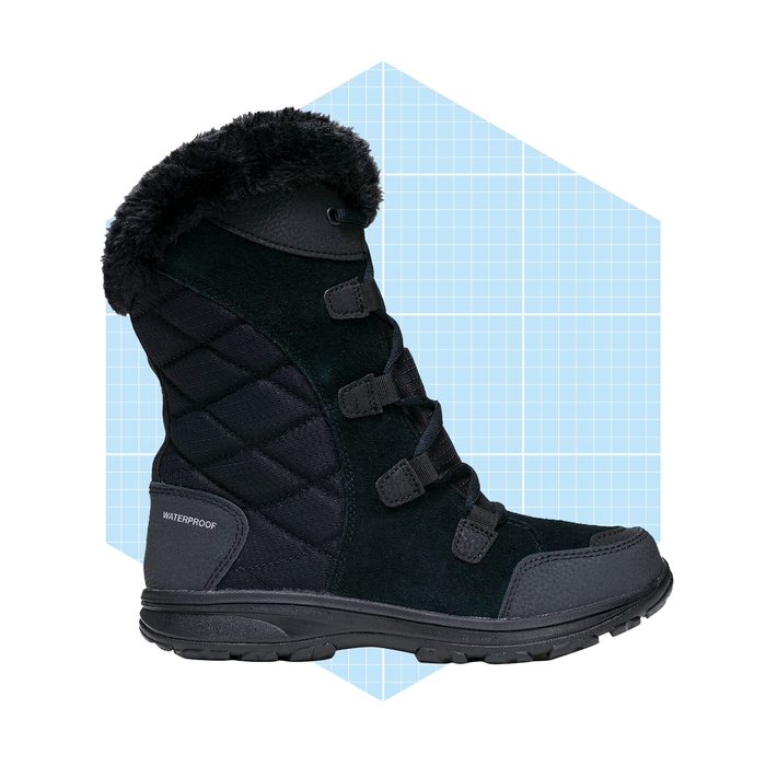 A black, waterproof boot stands upright, featuring a quilted design and faux fur trim, set against a light blue grid background.