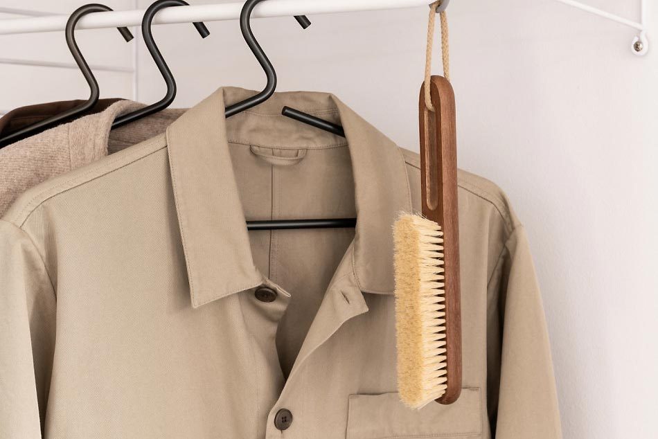 clothes and a brush hanging in a closet
