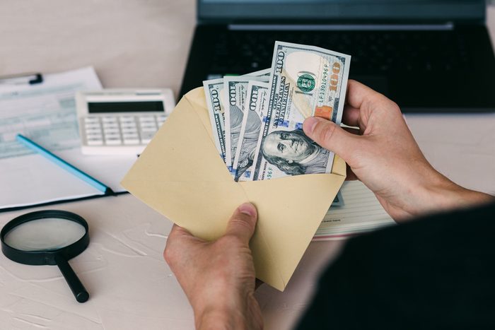 man's hand holds envelope with money