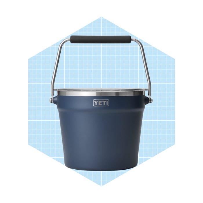 A dark blue bucket with a stainless steel rim and a handle sits in front of a grid-patterned light blue background.