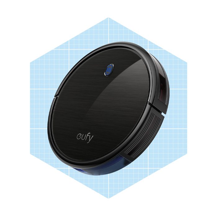 A robotic vacuum cleaner moves across a light blue grid background, designed for efficient cleaning with a sleek, round appearance and minimalistic control button.