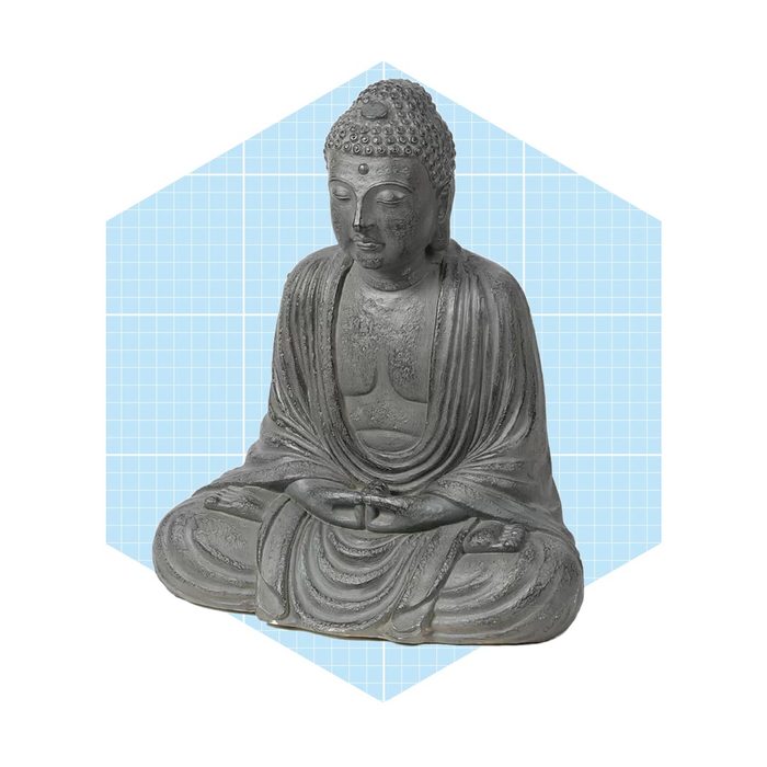 A seated Buddha statue, with hands in a meditative pose, positioned against a light blue, grid-patterned background.