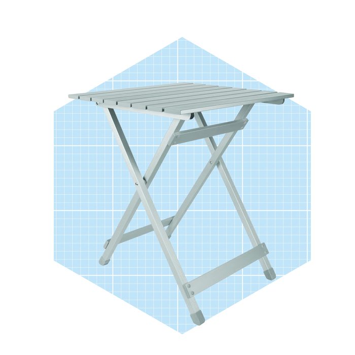 A light blue folding table stands upright against a grid-patterned background, ready for use in various settings.
