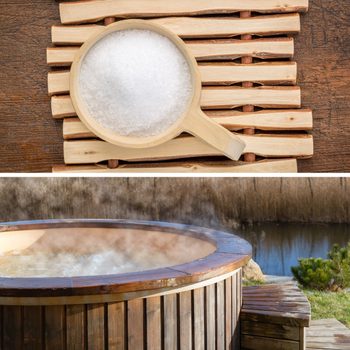 A wooden bowl holds coarse salt, placed on a bamboo mat. Below, a steaming hot tub sits by a tranquil water scene, surrounded by natural greenery.