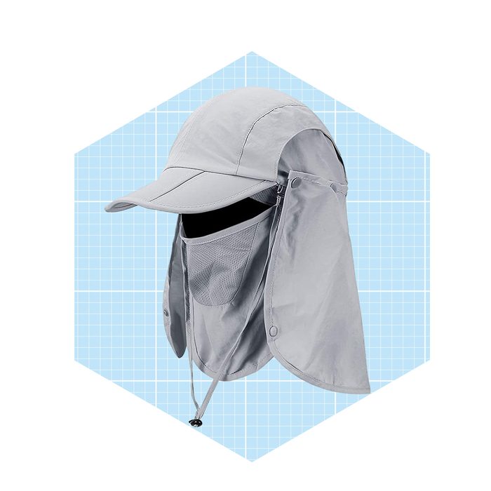 A gray cap with an attached neck flap and face covering is displayed against a light blue grid background, designed for sun protection.