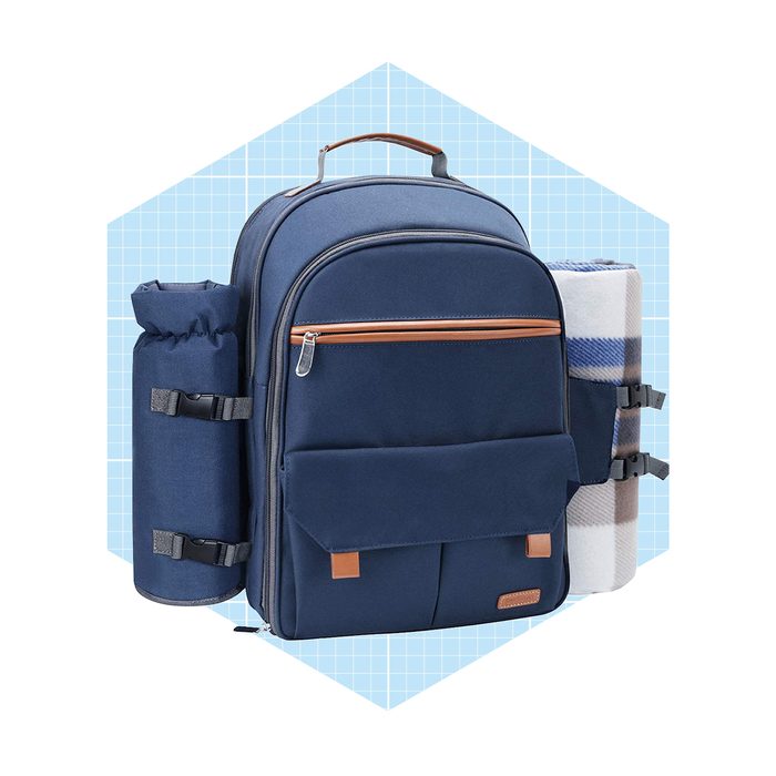 A navy backpack stands upright, featuring side compartments for carrying a drink and a rolled blanket, against a light blue grid background.