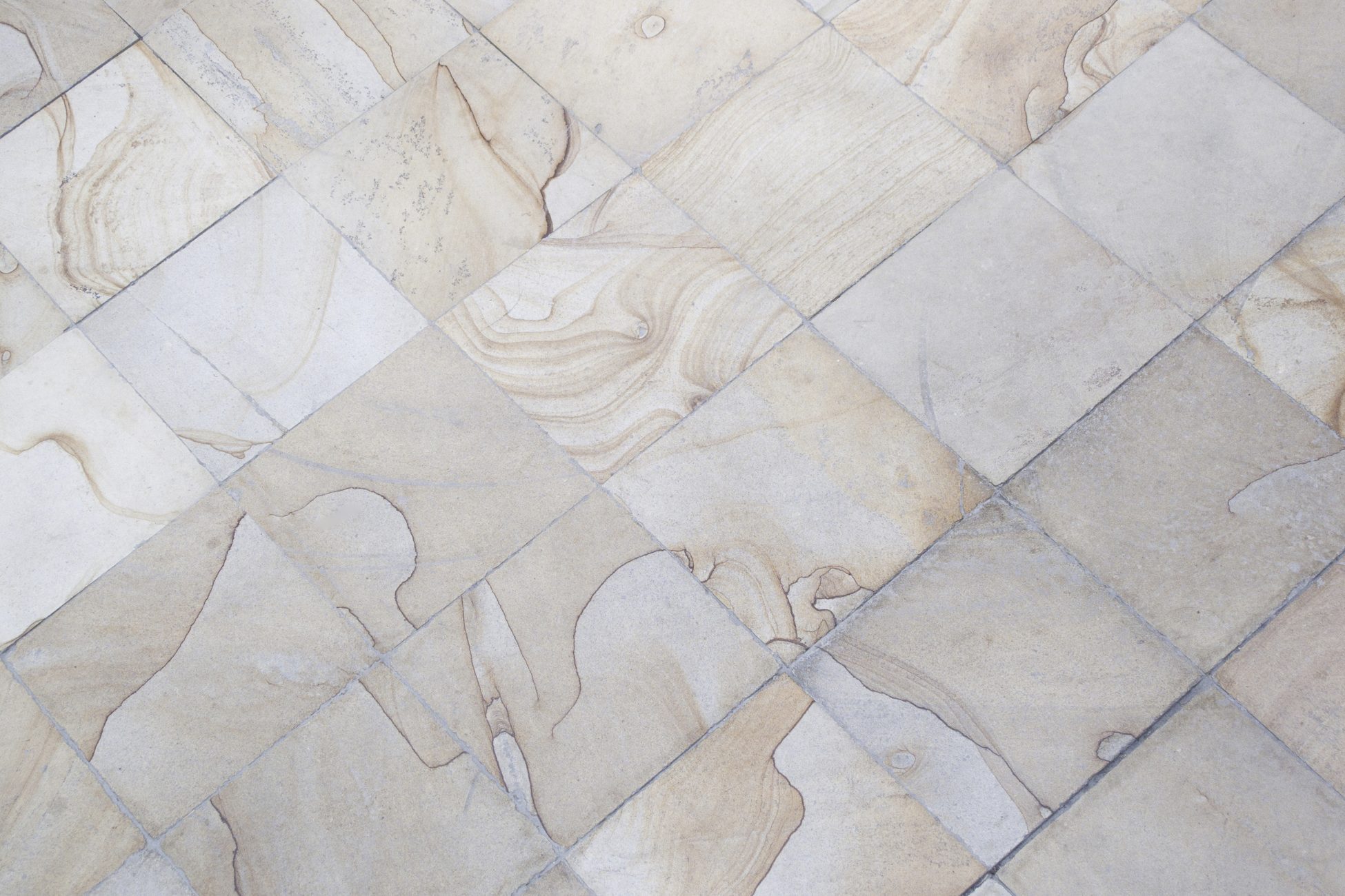 A patterned stone floor features light-colored tiles with swirls and textures, arranged in a grid, creating a natural, elegant appearance.