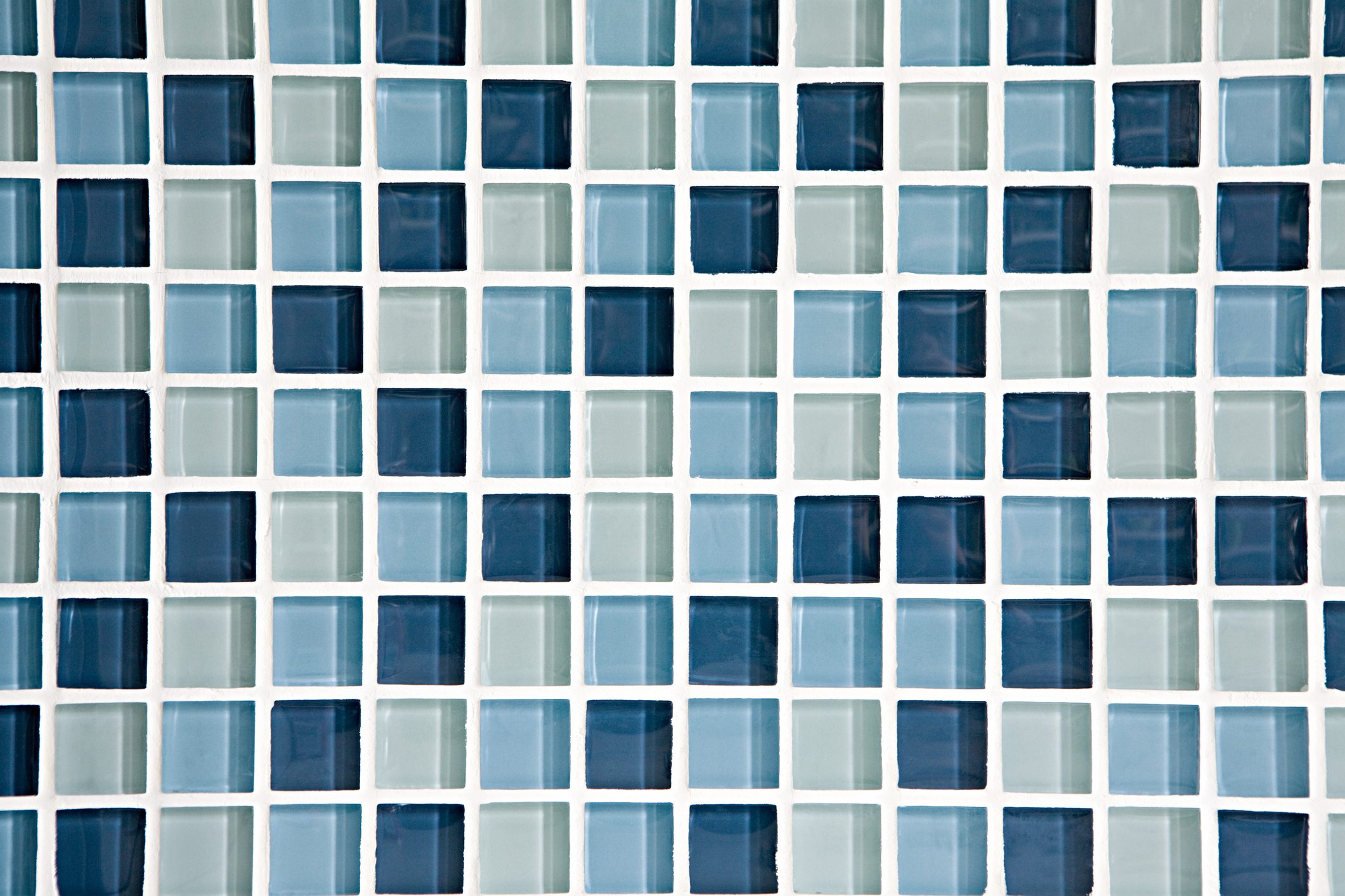 Square tiles in varying shades of blue and green are arranged in a grid pattern on a white backing, creating a cohesive mosaic effect.