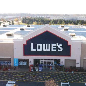 A large retail store displays the "Lowe's" sign, with shopping carts lined up outside and a striped parking area in front.