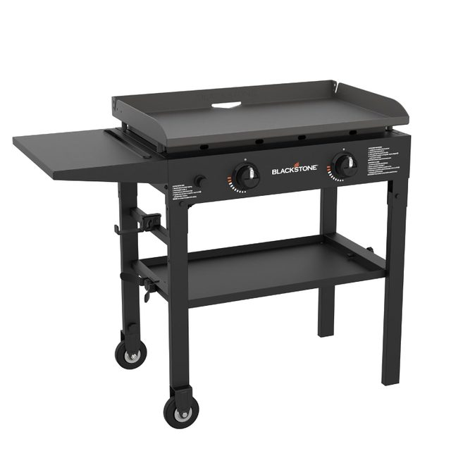 A gas griddle with two knobs on a wheeled cart, featuring a flat cooking surface and a side shelf, designed for outdoor cooking.