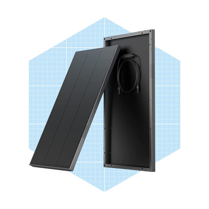 A solar panel leans against a frame, showcasing its black outer surface and wiring. The background features a light blue geometric pattern.