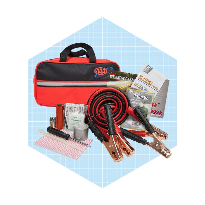 A red and black roadside emergency kit contains various tools, including jumper cables, a flashlight, and recovery items, all arranged in a carrying case.