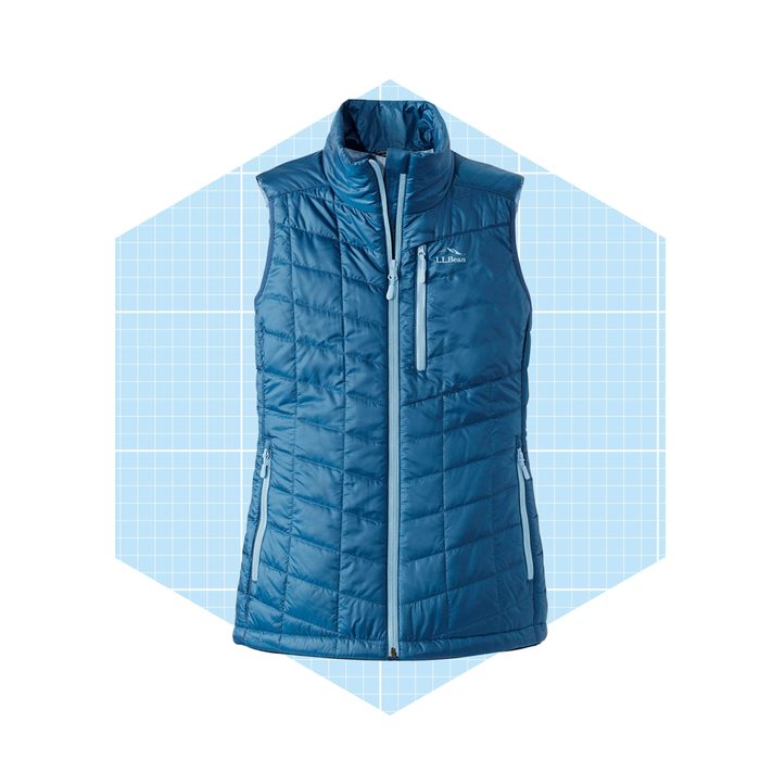 A blue puffer vest hangs upright, showcasing its design. Set against a light blue grid background, it appears ready for outdoor wear.