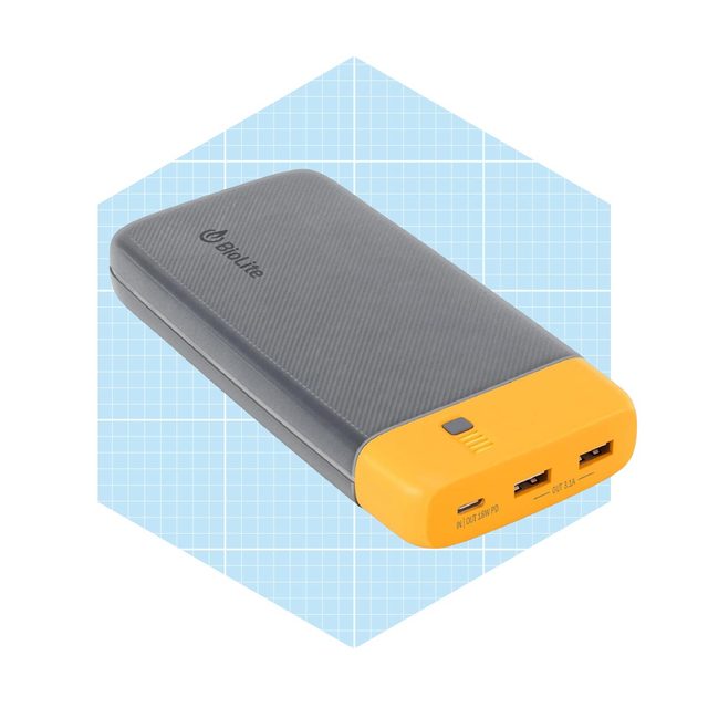 A power bank charges devices through two USB ports, resting against a light blue grid background with a textured gray and yellow design.