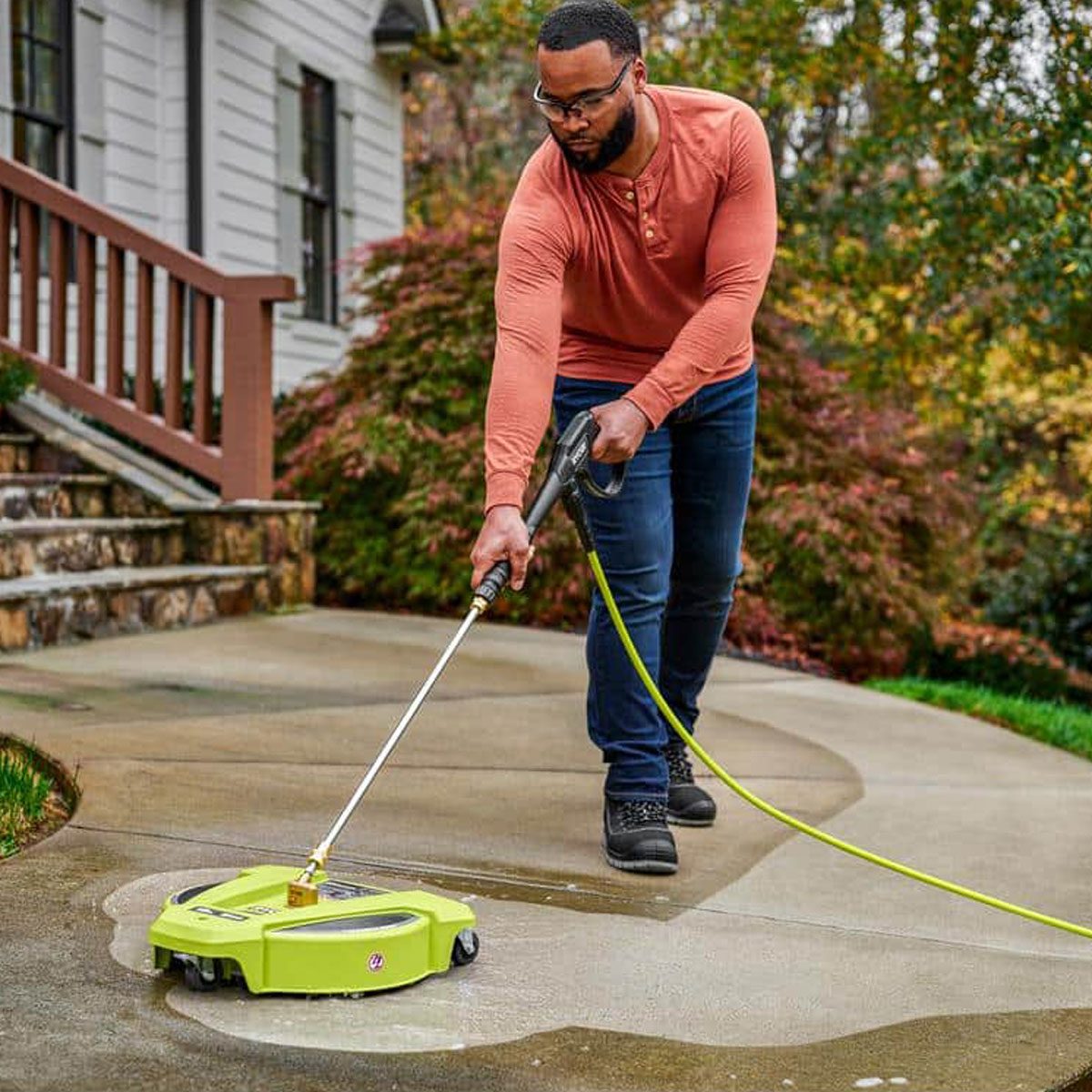 Ryobi 15 In. 3400 Psi Gas Pressure Washer Surface Cleaner With Caster Wheels being used to clean a front walkway