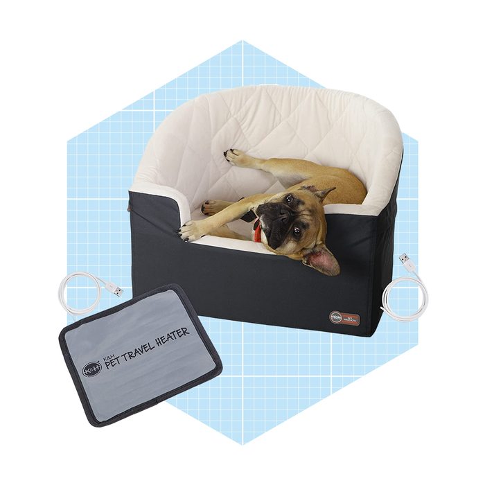 A dog lies comfortably in a plush pet bed, next to a USB pet travel heater, against a light blue grid background.
