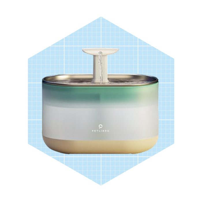 A stylish pet water fountain circulates water, providing hydration. The device features a gradient design with a small spout, placed against a blue grid background.
