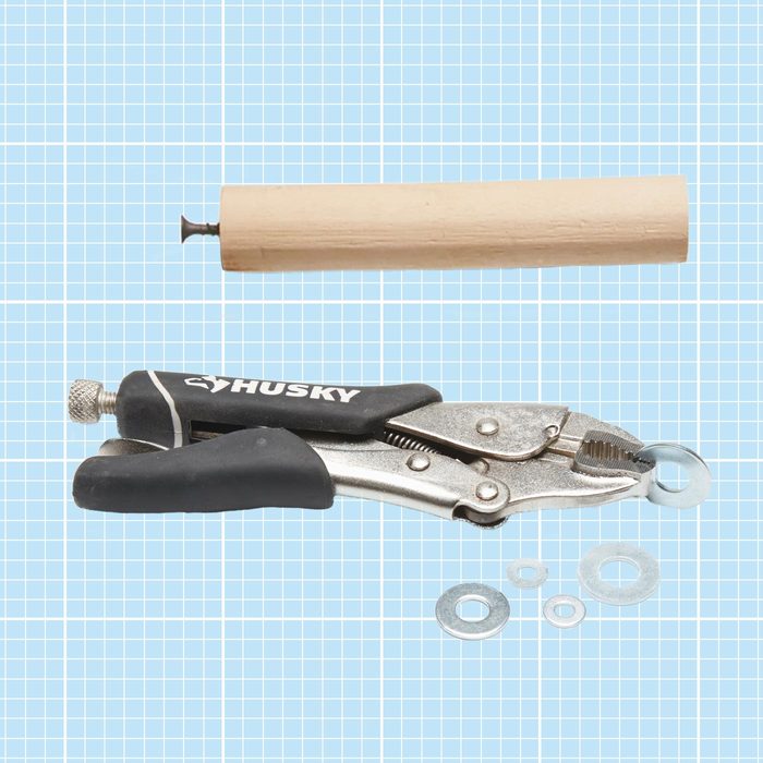 A piece of dowel with a drywall screw and pliers holding a washer