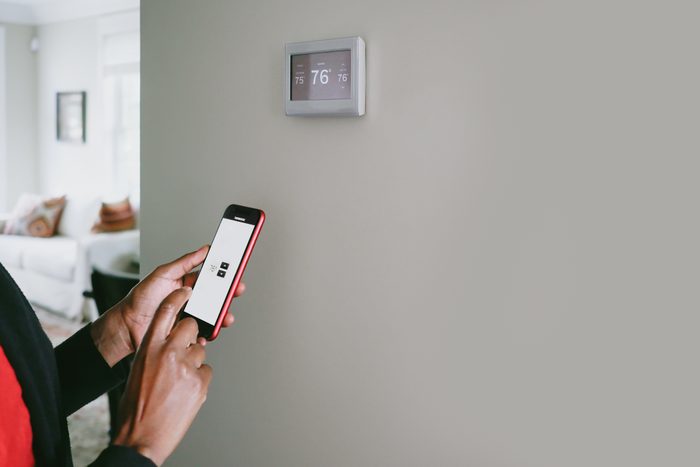 Woman Changes Thermostat From Smart Phone