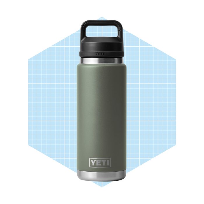 A green stainless steel water bottle with a handle stands upright against a light blue grid background, displaying the logo 