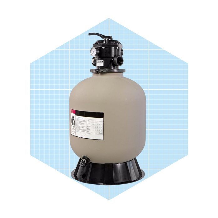 A cylindrical sand filter stands on a black base, featuring a top valve and pressure gauge, against a light blue grid background.