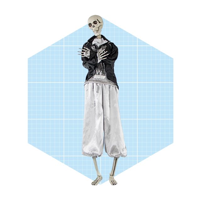 A skeleton stands with crossed arms, wearing a black jacket and white pants, set against a light blue, grid-patterned background.