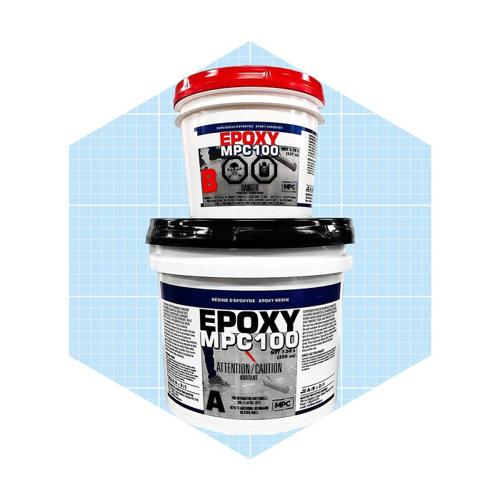Two buckets of epoxy resin are stacked, one larger with a black lid and a warning label, the smaller on top with a red lid. Background is light blue grid.