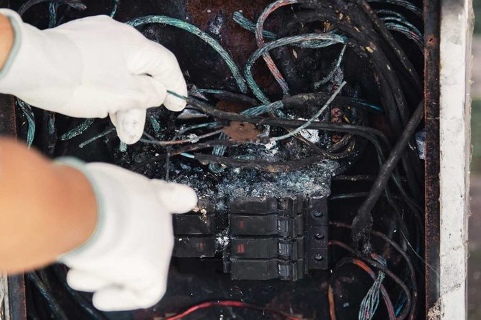 The Technician Is Investigating The Cause Of The Fire in an Electric Control Cabinet.