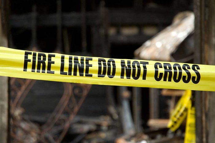 Fire Line Caution Tape in front of a Destroyed Home due to Fire Damage