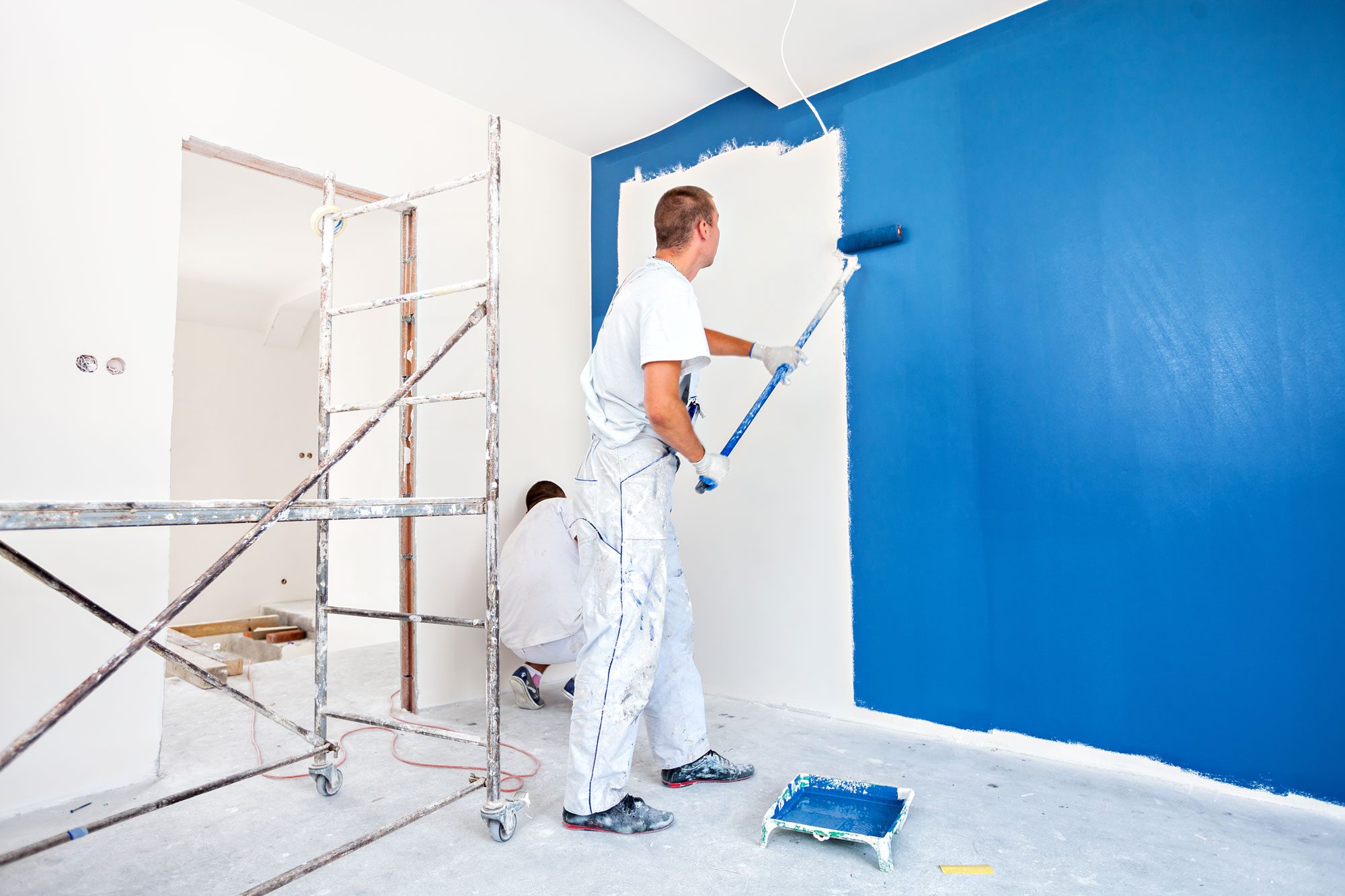 House Painters Painting A Wall In Blue