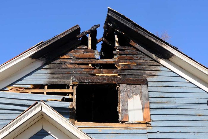 Blue Wooden Home With The Roof Burned Away