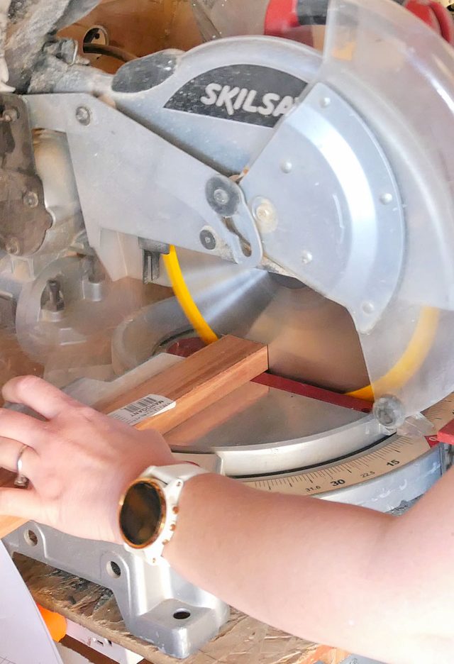 A woman using a circular saw to cut wood.