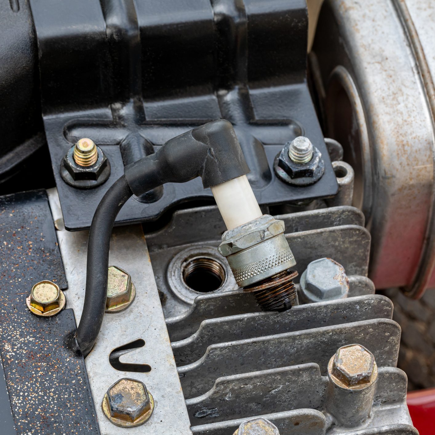Spark plug removed from lawn mower engine. Lawn and garden equipment repair, maintenance and service.