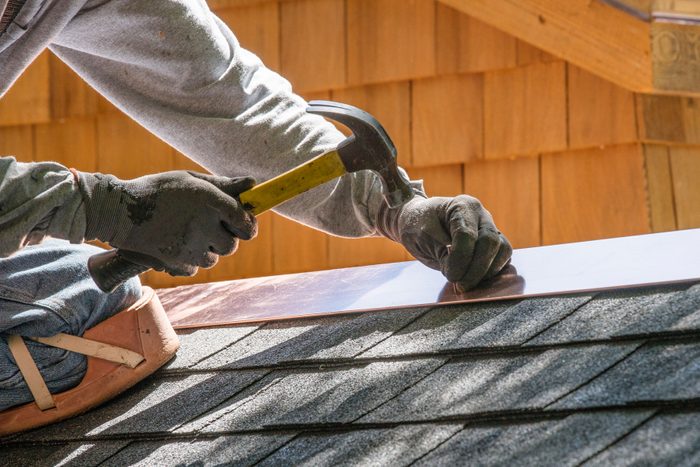 Hands can be seen nailing aluminium flashing